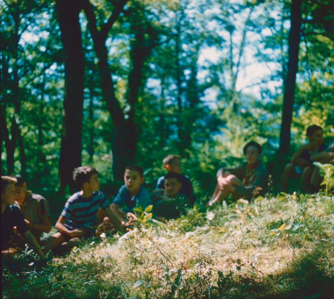 Group of cheerful older adults sitting in a circle and talking in a bright community room